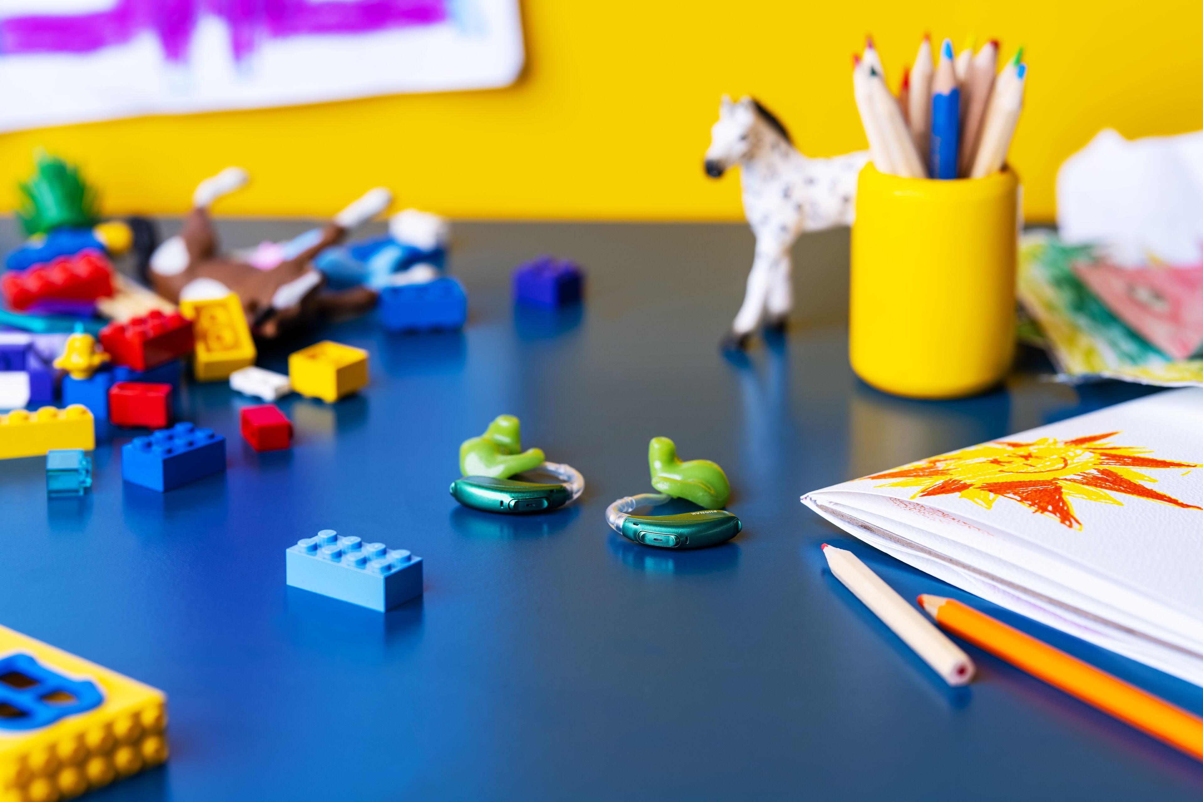 Bunte Hörgeräte und Kinderspielzeug
