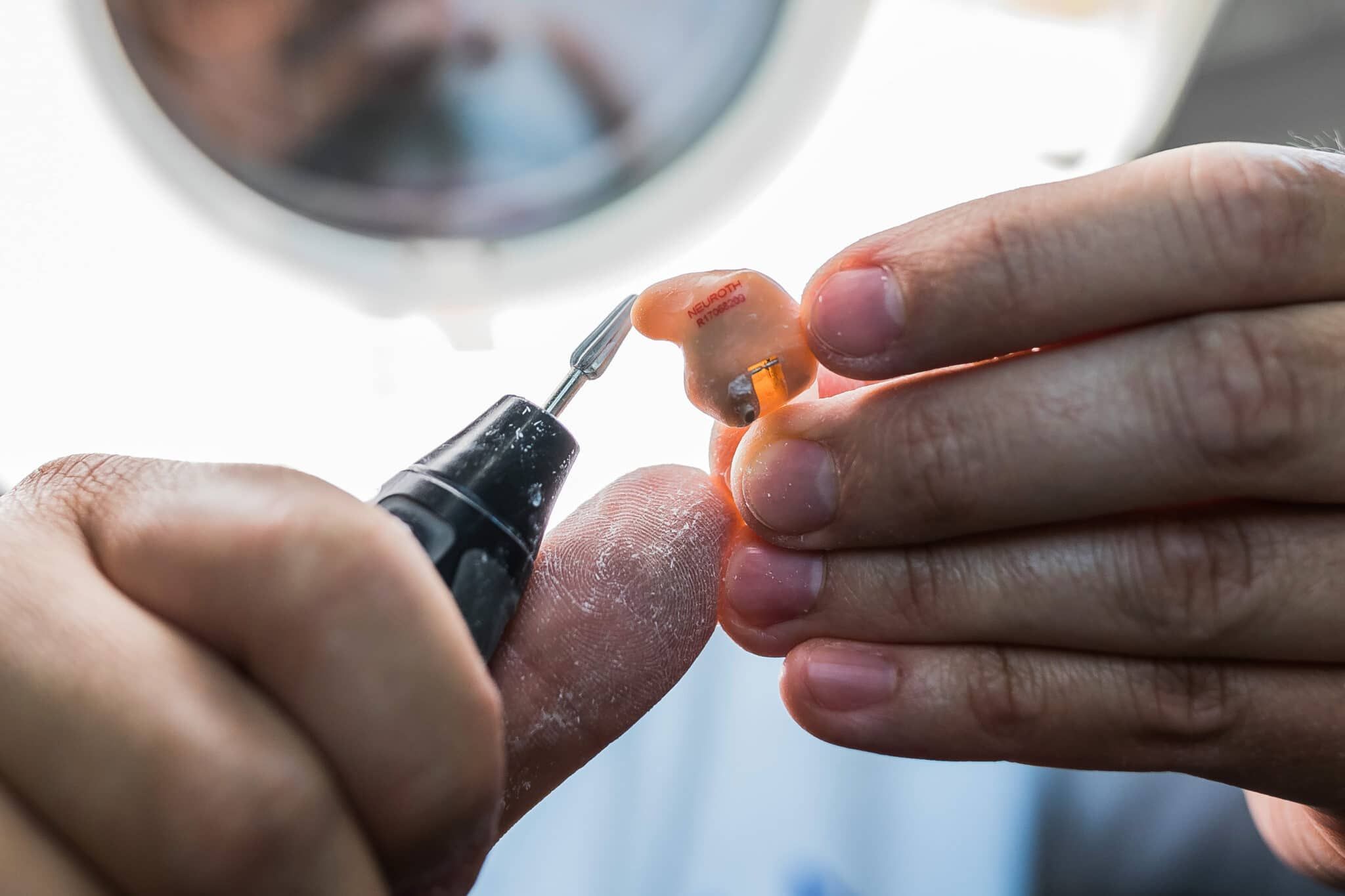 Otoplastik wird per Hand geschliffen und so individuell angepasst