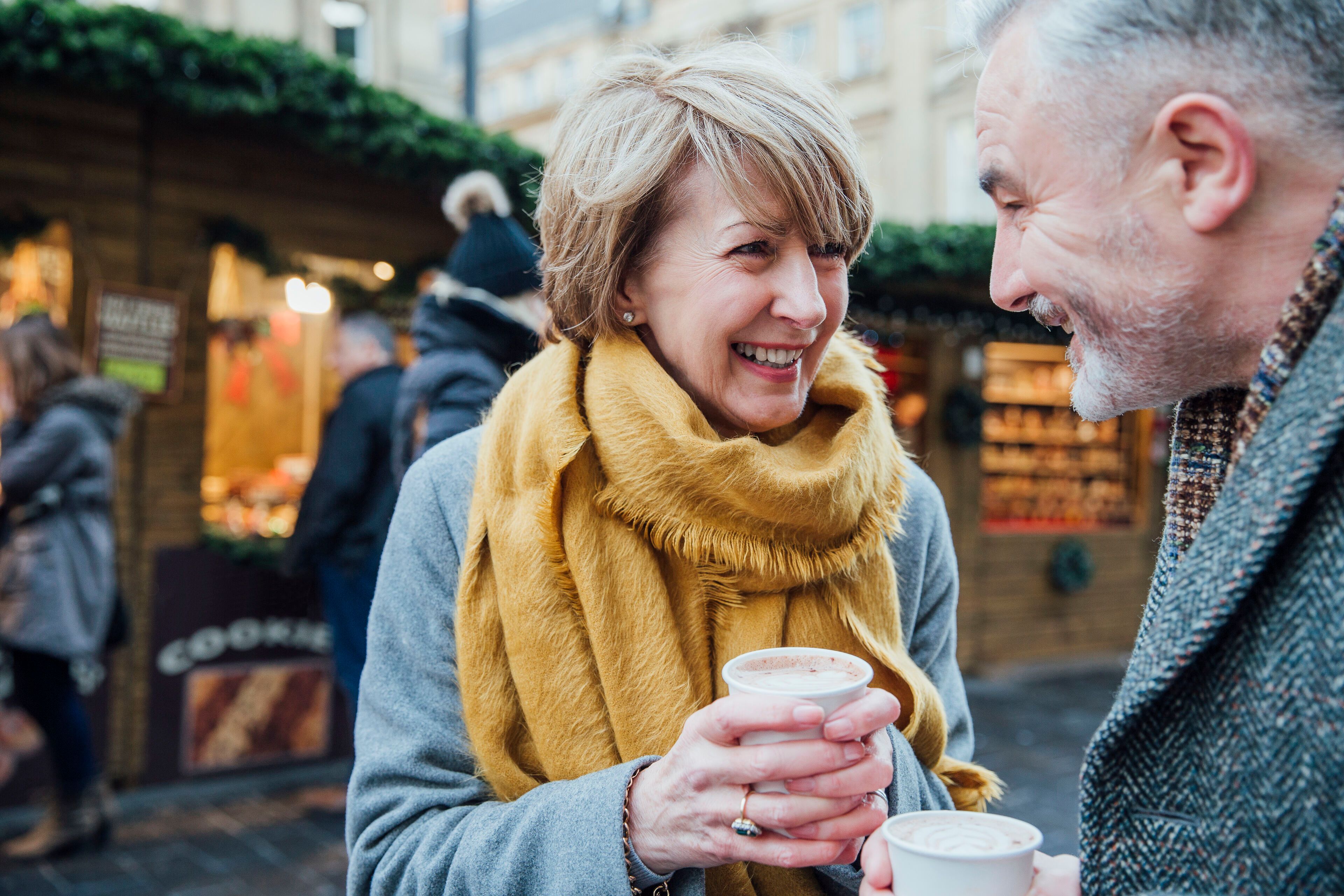 Ehepaar genießt Glühwein am Weihnachtsmarkt 