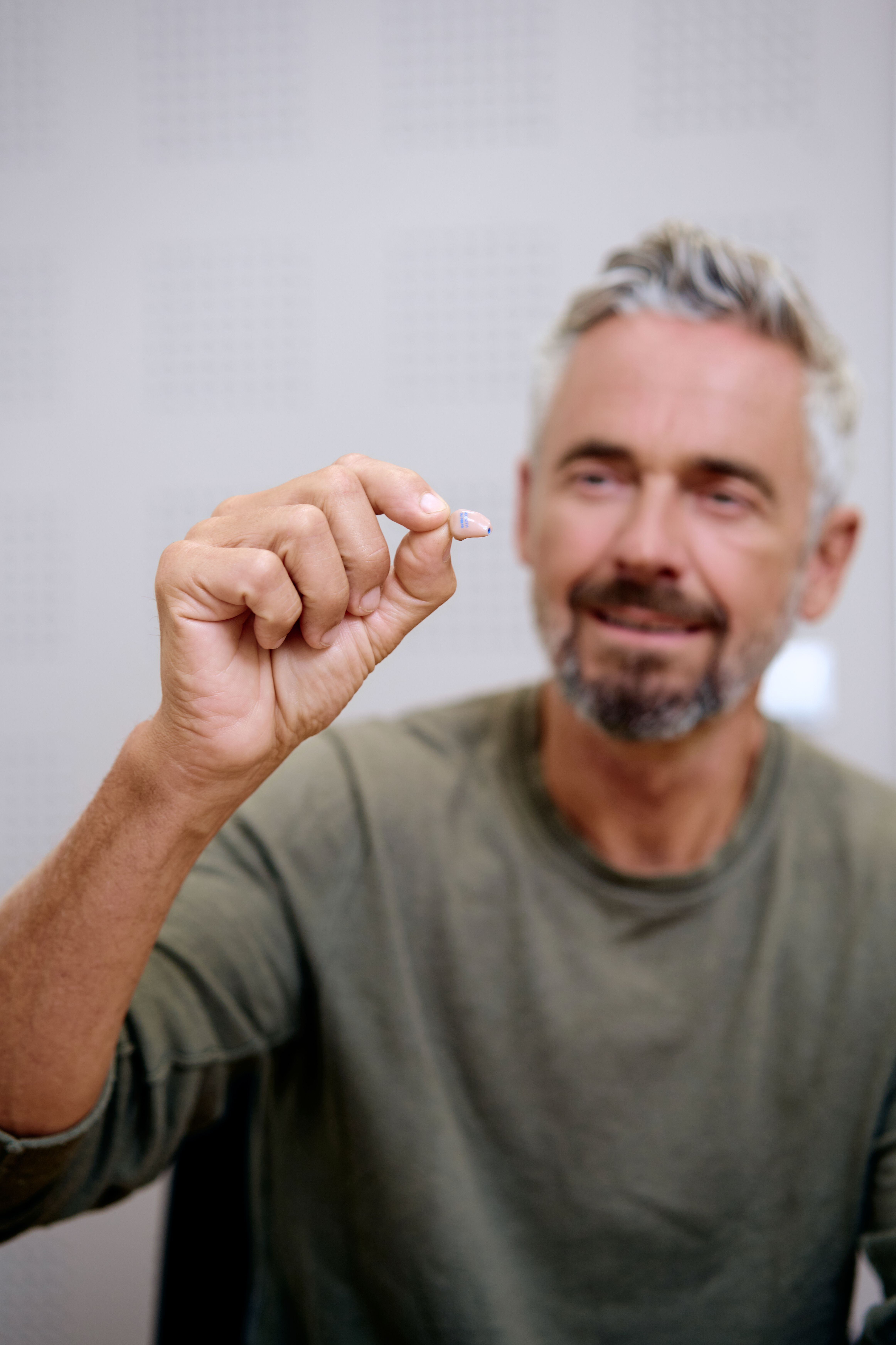 Mann hält Hörgerät in der Hand